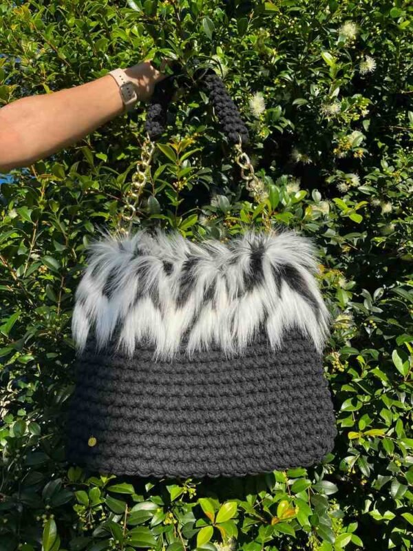 bolso comprimido menos 100kb Bolso de crochet con pelo blanco y negro sostenido por el asa