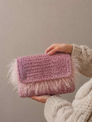 Bolso de crochet rosa con pelo sostenido en la mano